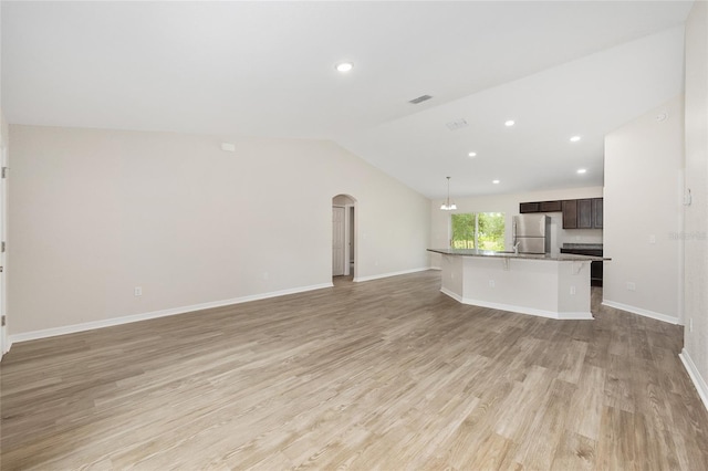 5 Water Pass, Ocala, FL 34472 - unfurnished living room with lofted ceiling, light wood-type flooring, arched walkways, and recessed lighting