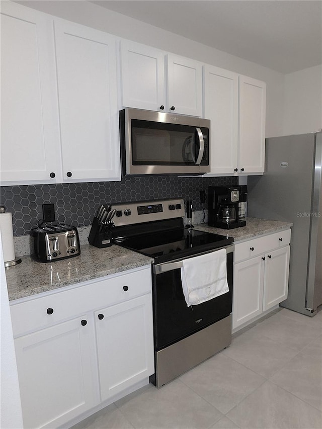 80 Hickory Course Loop, Ocala, FL 34472 - kitchen featuring appliances with stainless steel finishes, white cabinetry, backsplash, and light tile patterned floors