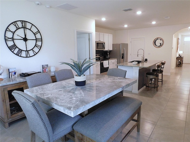 80 Hickory Course Loop, Ocala, FL 34472 - dining area featuring arched walkways, light tile patterned floors, recessed lighting, and beverage cooler