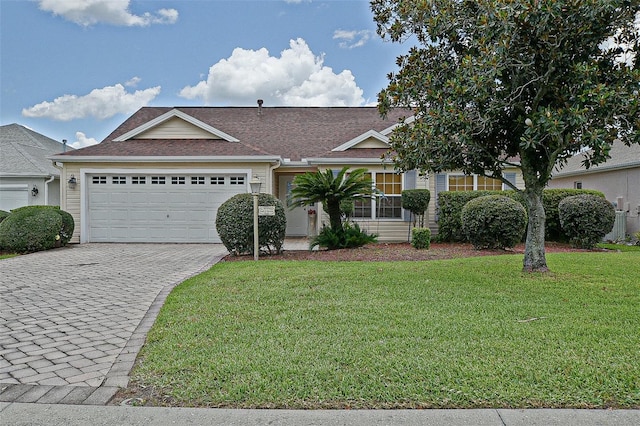 3146 Williams Rd, The Villages, FL 32162 - view of front of house featuring a front lawn, roof with shingles, decorative driveway, and a garage