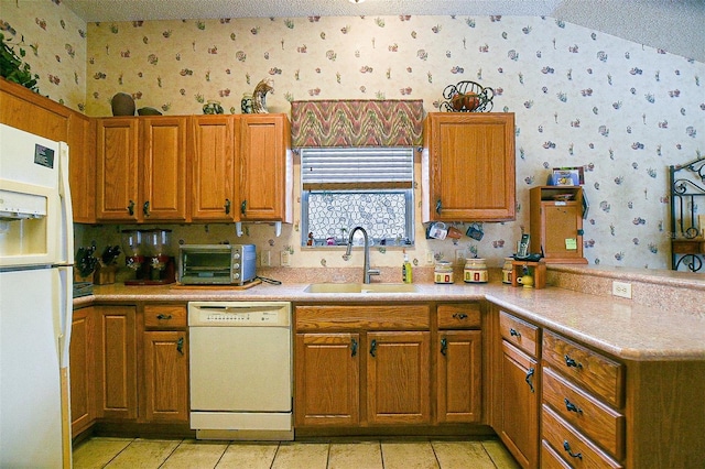 3146 Williams Rd, The Villages, FL 32162 - kitchen with white appliances, wallpapered walls, a textured ceiling, a peninsula, and brown cabinetry