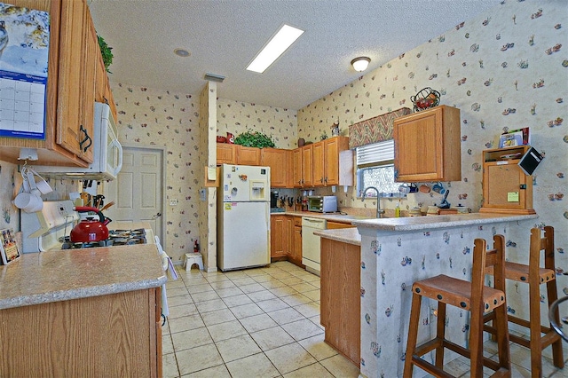 3146 Williams Rd, The Villages, FL 32162 - kitchen featuring white appliances, wallpapered walls, a peninsula, a textured ceiling, and light countertops