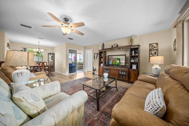 8461 SW 109th St, Ocala, FL 34481 - living area featuring a ceiling fan, a textured ceiling, a chandelier, and wood finished floors