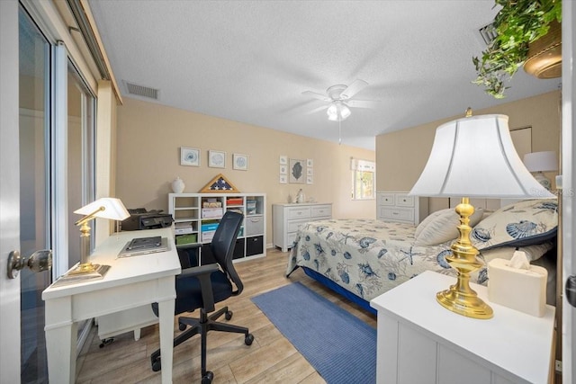 8461 SW 109th St, Ocala, FL 34481 - bedroom featuring light wood-style flooring, an office area, a textured ceiling, and a ceiling fan