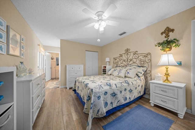 8461 SW 109th St, Ocala, FL 34481 - bedroom featuring light wood finished floors, a textured ceiling, a closet, connected bathroom, and a ceiling fan