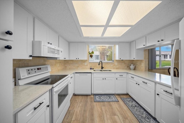 8461 SW 109th St, Ocala, FL 34481 - kitchen featuring white appliances, light wood finished floors, a textured ceiling, light countertops, and white cabinets