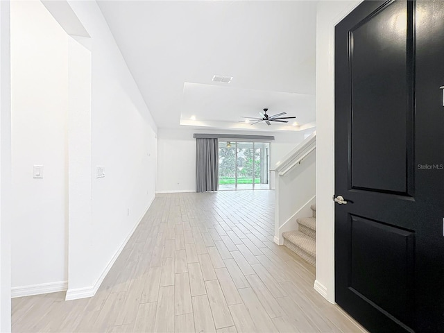 7067 SW 60th Ln, Ocala, FL 34474 - hall with a tray ceiling, stairs, and light wood-style flooring
