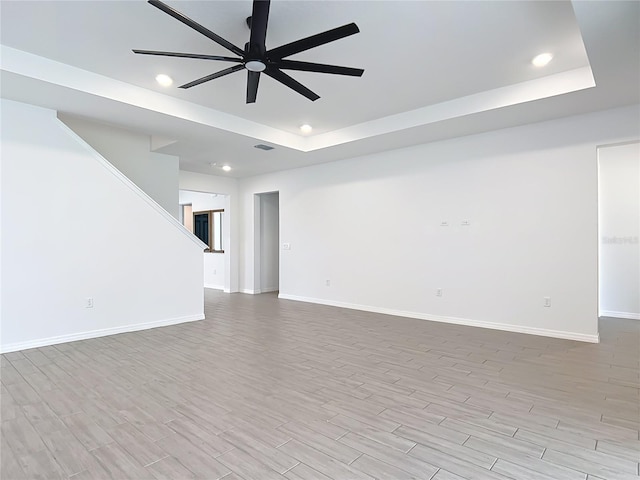 7067 SW 60th Ln, Ocala, FL 34474 - spare room with ceiling fan, a raised ceiling, wood finished floors, recessed lighting, and stairs