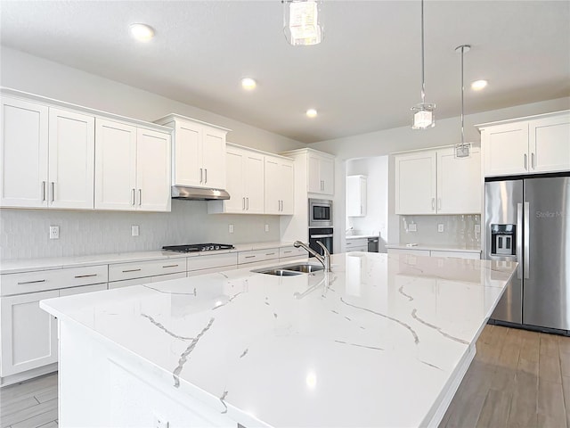 7067 SW 60th Ln, Ocala, FL 34474 - kitchen with stainless steel appliances, a large island with sink, under cabinet range hood, white cabinets, and recessed lighting