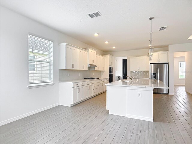 7067 SW 60th Ln, Ocala, FL 34474 - kitchen featuring stainless steel fridge with ice dispenser, gas cooktop, light countertops, light wood-style flooring, and recessed lighting