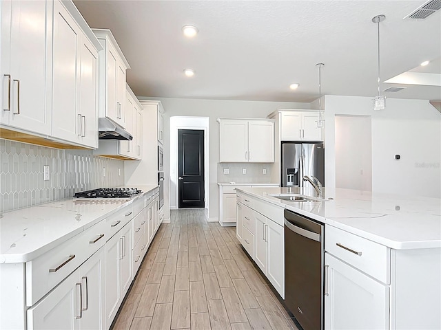 7067 SW 60th Ln, Ocala, FL 34474 - kitchen with stainless steel appliances, decorative backsplash, white cabinets, under cabinet range hood, and recessed lighting