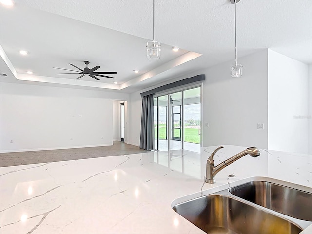 7067 SW 60th Ln, Ocala, FL 34474 - kitchen featuring a raised ceiling, decorative light fixtures, open floor plan, light stone countertops, and recessed lighting