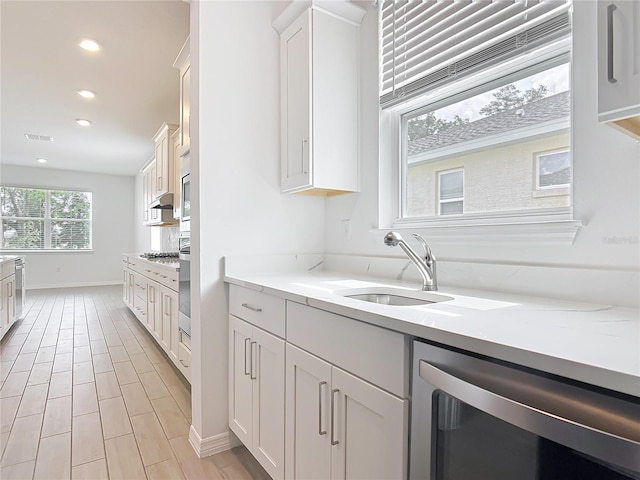 7067 SW 60th Ln, Ocala, FL 34474 - kitchen with stainless steel dishwasher, white cabinetry, recessed lighting, and light wood finished floors