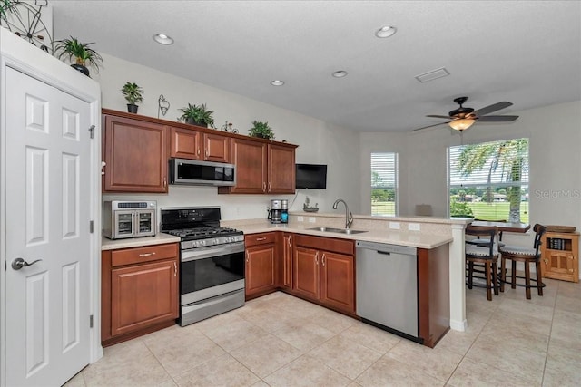 1443 SW 161st St, Ocala, FL 34473 - kitchen with stainless steel appliances, light countertops, a peninsula, ceiling fan, and light tile patterned floors