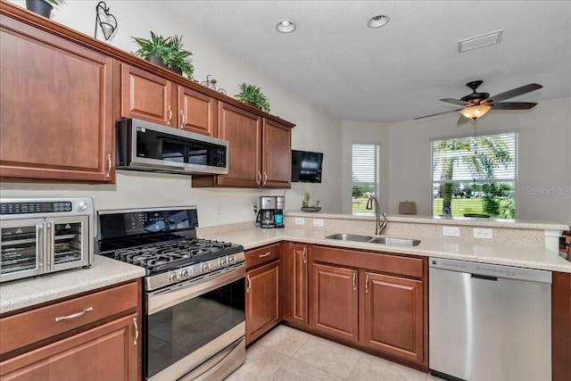 1443 SW 161st St, Ocala, FL 34473 - kitchen featuring stainless steel appliances, a peninsula, light countertops, light tile patterned flooring, and a ceiling fan
