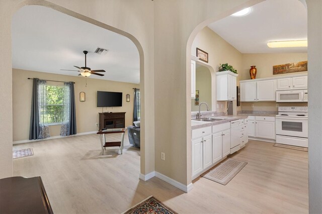 12178 SE 174th Pl, Summerfield, FL 34491 - kitchen featuring white appliances, arched walkways, a ceiling fan, light wood-style floors, and light countertops