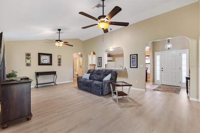 12178 SE 174th Pl, Summerfield, FL 34491 - living area with arched walkways, a ceiling fan, light wood-type flooring, and vaulted ceiling