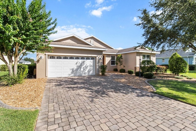 9926 SW 95th Loop, Ocala, FL 34481 - ranch-style house featuring stucco siding, decorative driveway, and a garage