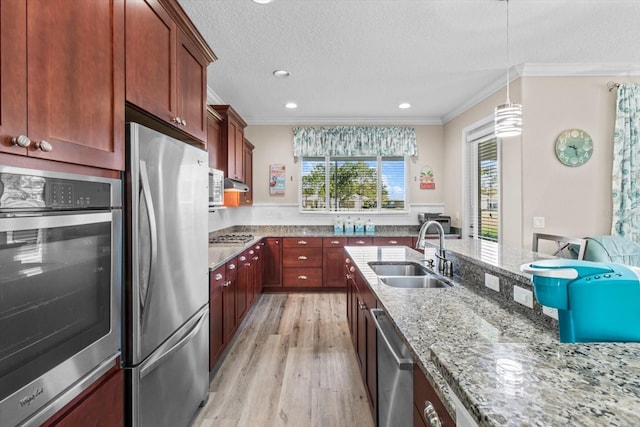9926 SW 95th Loop, Ocala, FL 34481 - kitchen featuring appliances with stainless steel finishes, crown molding, light wood-style flooring, light stone countertops, and decorative light fixtures