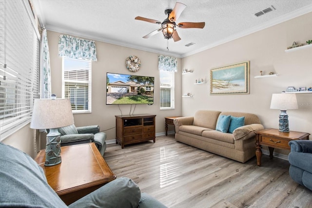 9926 SW 95th Loop, Ocala, FL 34481 - living room featuring light wood finished floors, plenty of natural light, crown molding, a ceiling fan, and a textured ceiling
