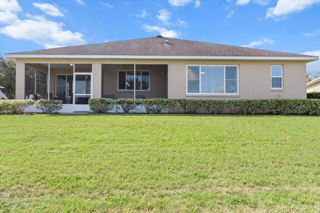 9926 SW 95th Loop, Ocala, FL 34481 - rear view of house with a lawn, stucco siding, and a sunroom