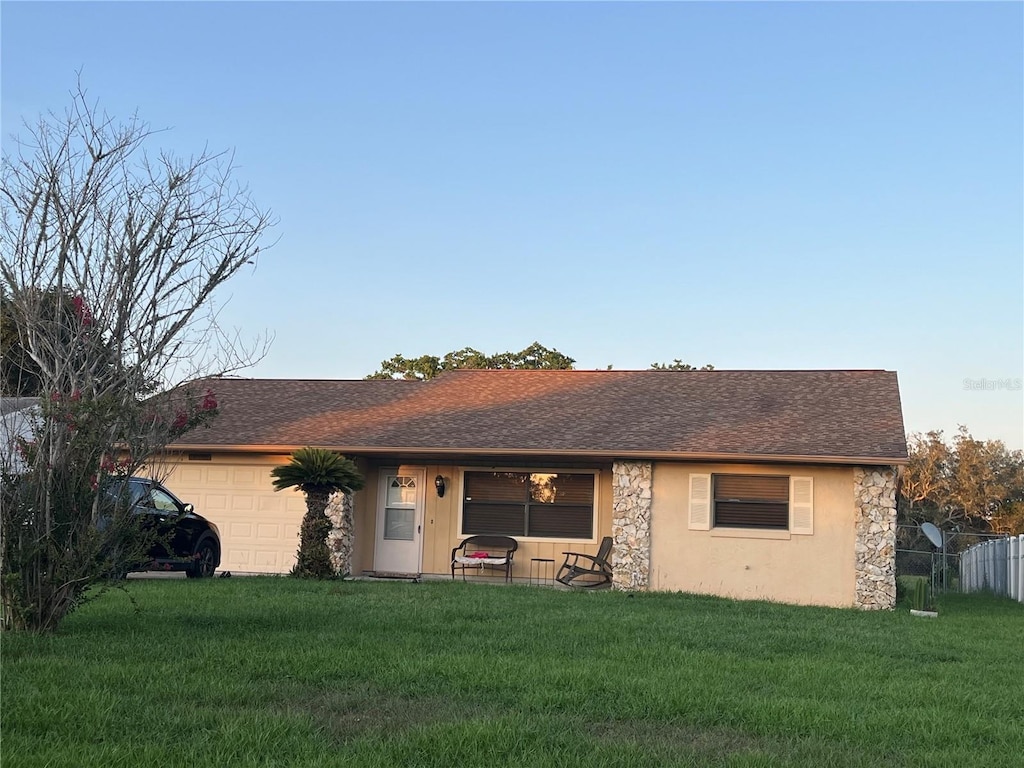 10885 SE 74th Ct, Belleview, FL 34420 - view of front of home with an attached garage, stone siding, and roof with shingles