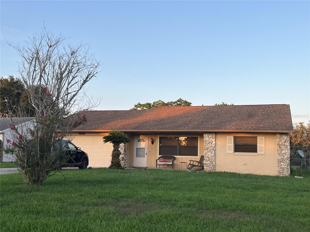 10885 SE 74th Ct, Belleview, FL 34420 - ranch-style home with a garage, a front lawn, stone siding, and a shingled roof