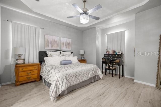 2418 SE 22nd Pl, Ocala, FL 34471 - bedroom featuring a tray ceiling, wood finished floors, and ceiling fan