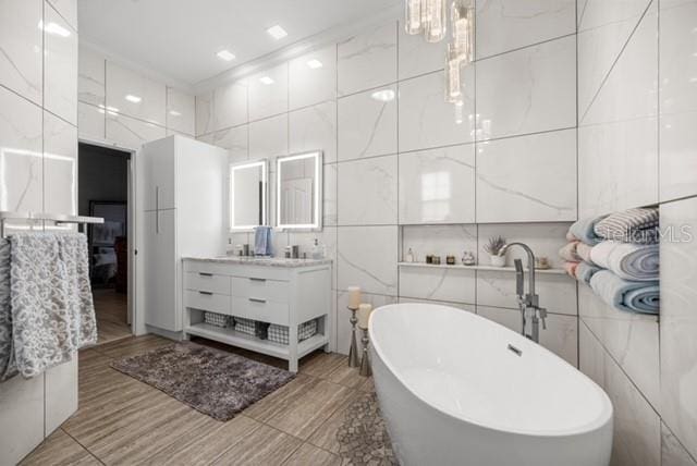 2418 SE 22nd Pl, Ocala, FL 34471 - bathroom with tile walls, double vanity, and a soaking tub