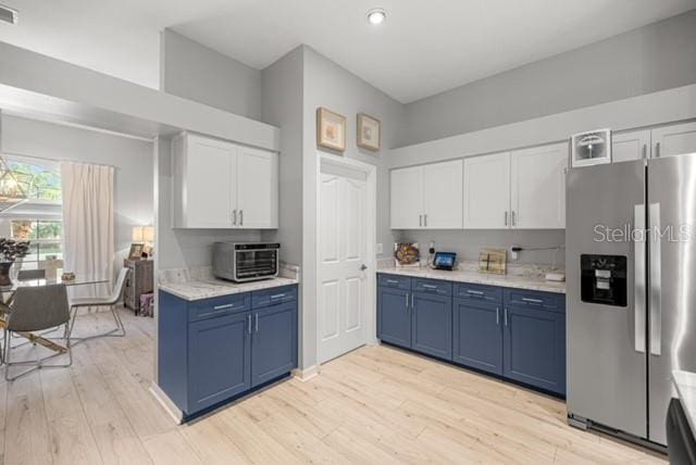 2418 SE 22nd Pl, Ocala, FL 34471 - kitchen featuring stainless steel refrigerator with ice dispenser, blue cabinets, light countertops, light wood finished floors, and recessed lighting