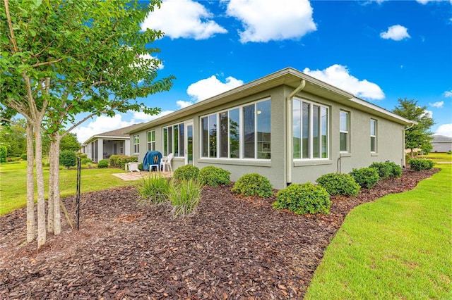 10597 SW 90th Street Rd, Ocala, FL 34481 - view of property exterior with a yard, stucco siding, and a patio