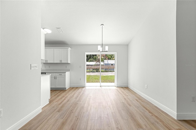 14876 SE 34th Ter, Summerfield, FL 34491 - unfurnished dining area with light wood-style floors and a chandelier