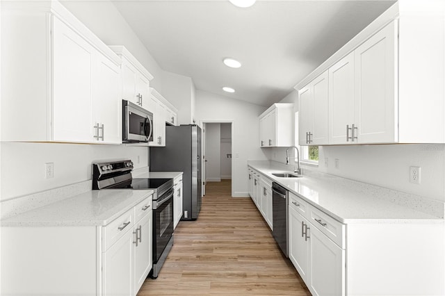 14876 SE 34th Ter, Summerfield, FL 34491 - kitchen featuring stainless steel appliances, light wood finished floors, vaulted ceiling, white cabinets, and recessed lighting