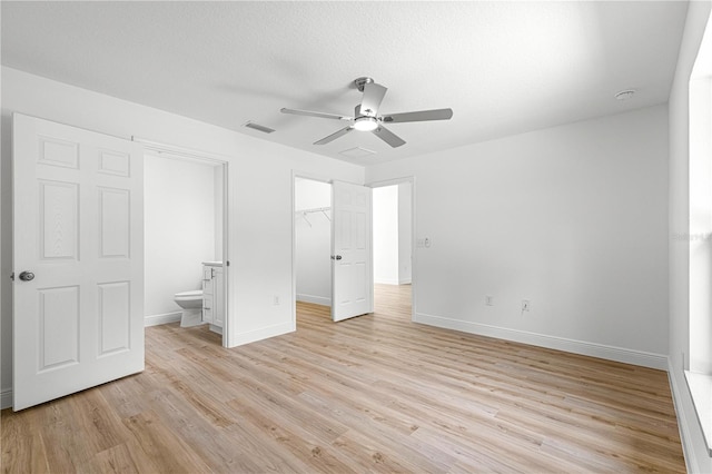 14876 SE 34th Ter, Summerfield, FL 34491 - unfurnished bedroom with light wood finished floors, a spacious closet, a closet, and a ceiling fan