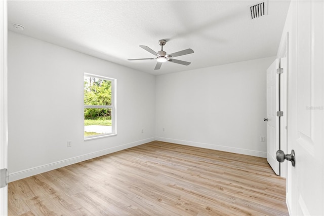 14876 SE 34th Ter, Summerfield, FL 34491 - empty room with a ceiling fan, light wood-style floors, a smoke detector, and a textured ceiling
