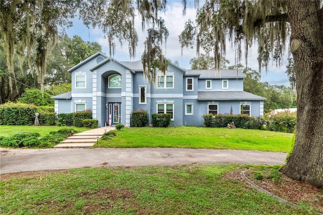 3549 SE 41st Pl, Ocala, FL 34480 - view of front of property featuring a front yard, stucco siding, and roof with shingles