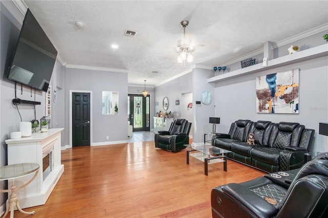 3549 SE 41st Pl, Ocala, FL 34480 - living area featuring a textured ceiling, light wood finished floors, a ceiling fan, and ornamental molding