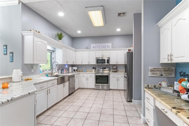3549 SE 41st Pl, Ocala, FL 34480 - kitchen featuring appliances with stainless steel finishes, white cabinetry, light countertops, light tile patterned flooring, and recessed lighting