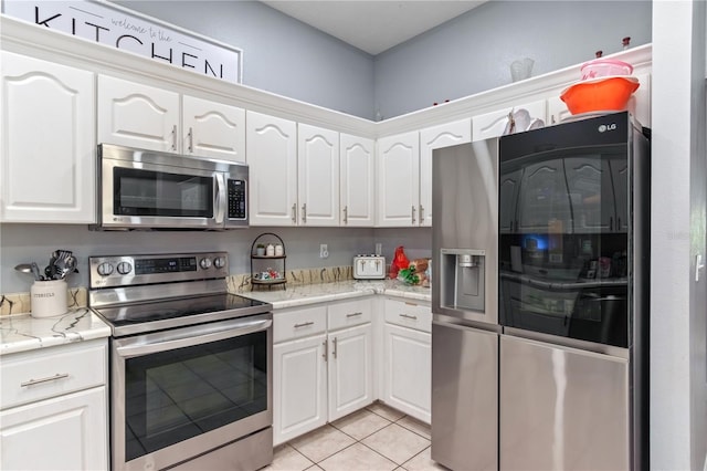 3549 SE 41st Pl, Ocala, FL 34480 - kitchen featuring appliances with stainless steel finishes, white cabinets, light tile patterned floors, and light stone counters