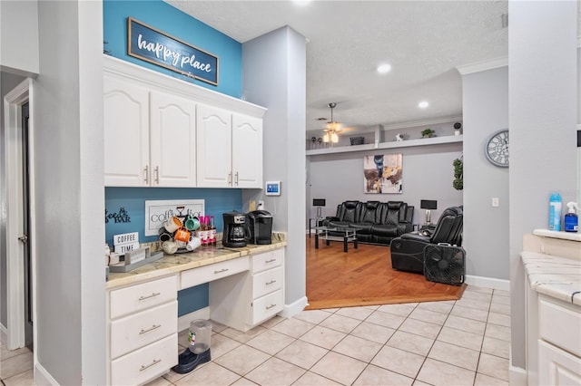 3549 SE 41st Pl, Ocala, FL 34480 - kitchen with built in desk, a ceiling fan, white cabinets, light tile patterned floors, and open floor plan