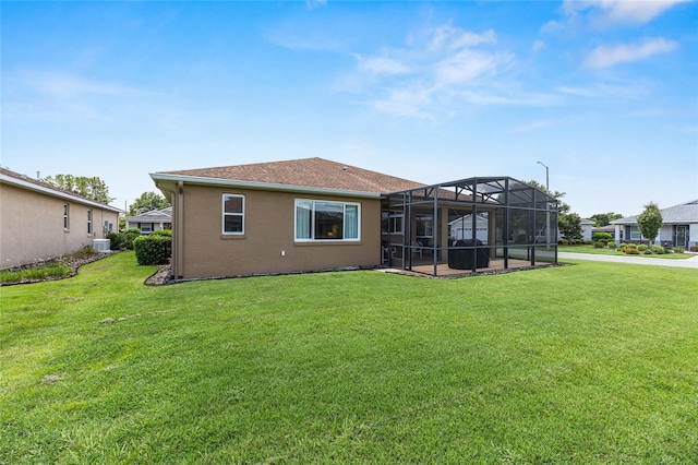 9222 SW 97th Cir, Ocala, FL 34481 - rear view of house with a yard, glass enclosure, and stucco siding