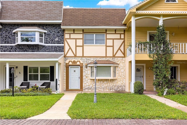8830 SW 98th Pl Unit M, Ocala, FL 34481 - townhome / multi-family property featuring stone siding, roof with shingles, and a front yard