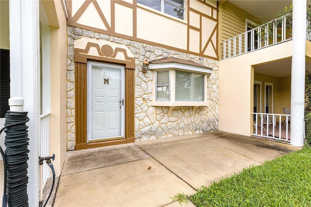 8830 SW 98th Pl Unit M, Ocala, FL 34481 - property entrance with stone siding, a balcony, and stucco siding
