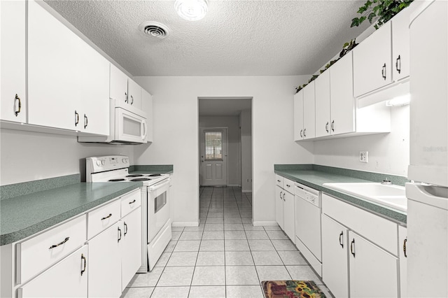 8830 SW 98th Pl Unit M, Ocala, FL 34481 - kitchen featuring white appliances, a textured ceiling, light tile patterned floors, and white cabinetry