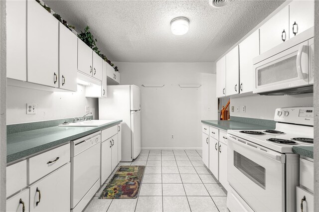 8830 SW 98th Pl Unit M, Ocala, FL 34481 - kitchen with white appliances, a textured ceiling, white cabinets, and light tile patterned floors