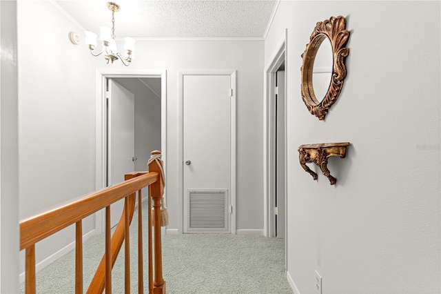 8830 SW 98th Pl Unit M, Ocala, FL 34481 - corridor featuring ornamental molding, an upstairs landing, a chandelier, carpet, and a textured ceiling