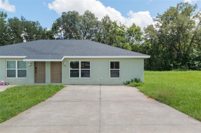 2139 NE 78th Ln, Ocala, FL 34479 - view of front facade featuring roof with shingles, driveway, a front yard, and stucco siding