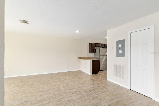 2139 NE 78th Ln, Ocala, FL 34479 - unfurnished living room featuring electric panel and light wood-style floors