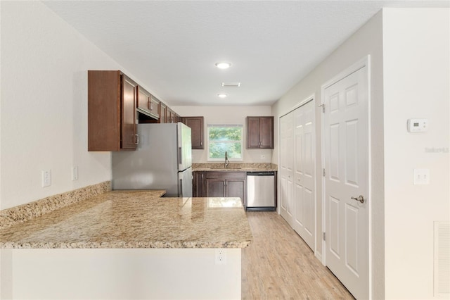 2139 NE 78th Ln, Ocala, FL 34479 - kitchen featuring stainless steel appliances, a peninsula, light wood-style floors, recessed lighting, and dark brown cabinetry