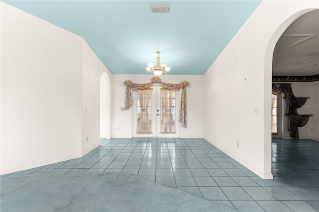 6172 SW 101st Pl, Ocala, FL 34476 - empty room featuring arched walkways, a chandelier, tile patterned floors, and french doors